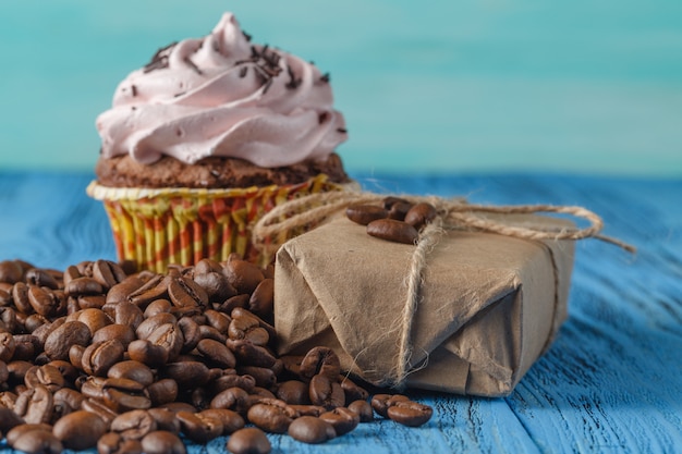 Cupcake and coffee beans on table