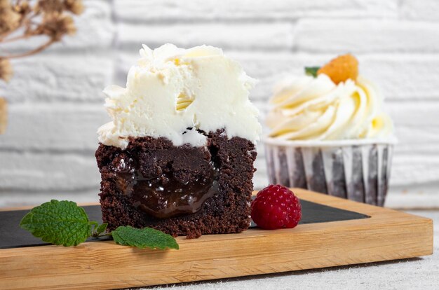 Cupcake cut in half from which the sweet filling flows out on a white plate Closeup