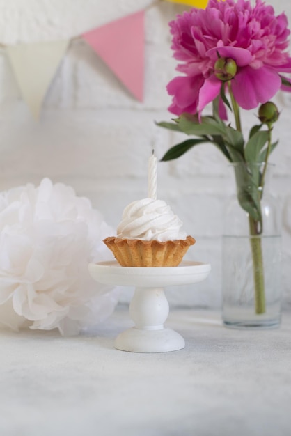 Cupcake on a stand with pink flowers and on a white background