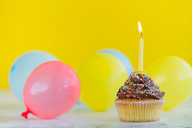 Cupcake with candle and balloons