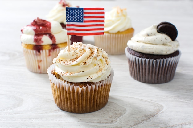 cupcakes of different flavors on a white wooden table