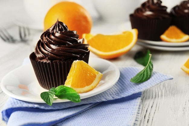 Cupcakes served with orange and drink on table