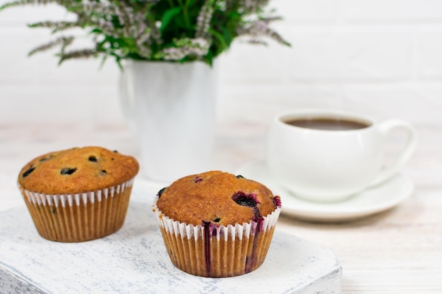 Cupcakes with black currant and mint leaves on a white plate Selective focus