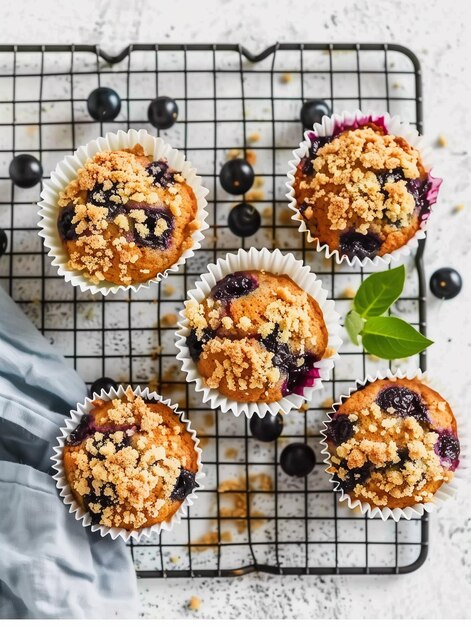 Photo cupcakes with chocolate chips and cranberries on a cooling rack on a white kitchen table