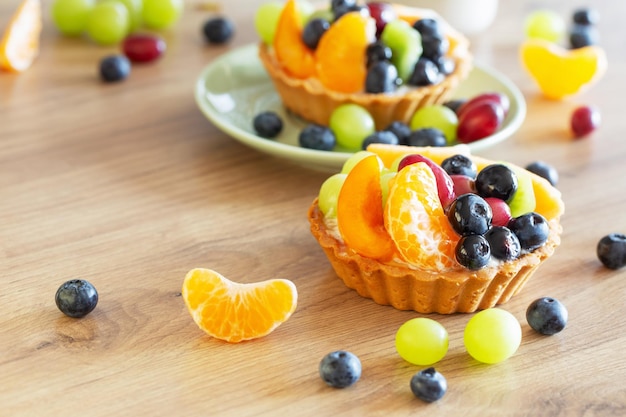 cupcakes with fruits on wooden table on kitchen