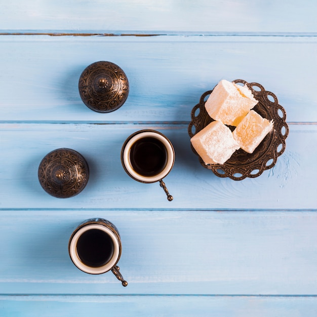 Cups of coffee near saucer with Turkish delights