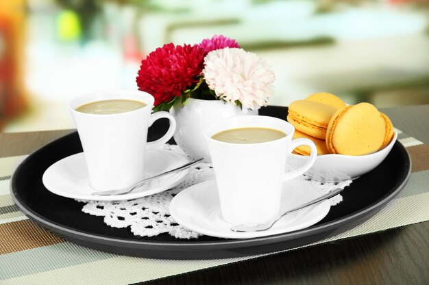 Cups of coffee on tray on table in cafe