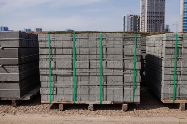 Curb stone on construction site. Pallet with a stack of concrete curbstone. Road repairs.