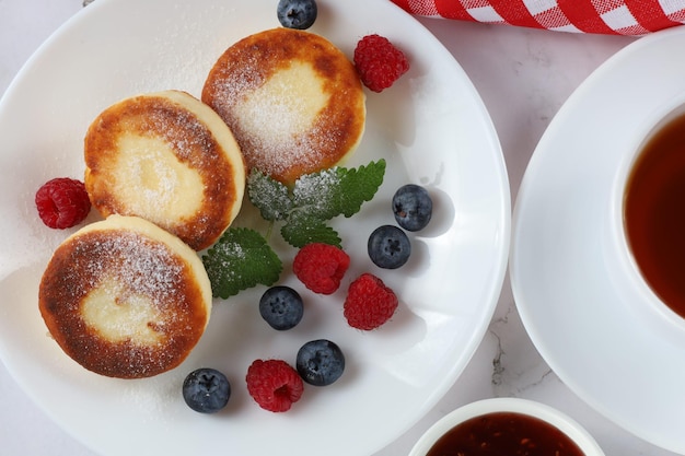 Curd fritter with berries in a plate Cottage cheese fritters