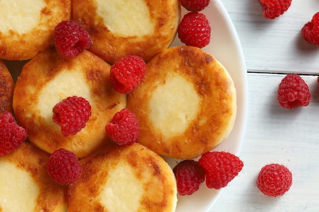 Curd fritters on a plate with raspberries Delicious homemade food