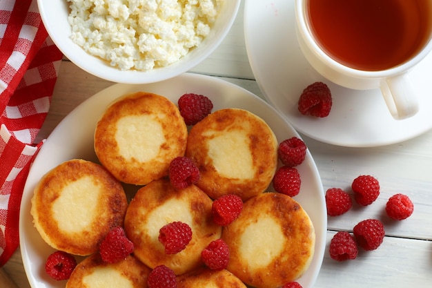 Curd fritters with raspberries Traditional breakfast Food on a bright table