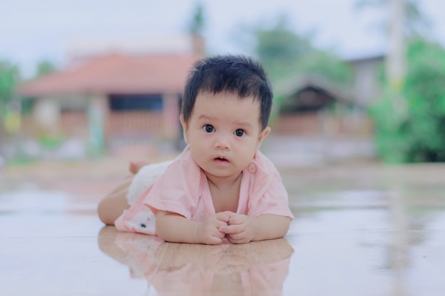 Curious baby, little baby laying on ground