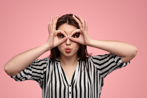 Curious lady pouting lips and gesturing eyeglasses