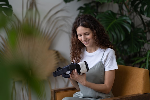 Curious woman with futuristic innovative vr glasses in surrounding of tropical exotic plants