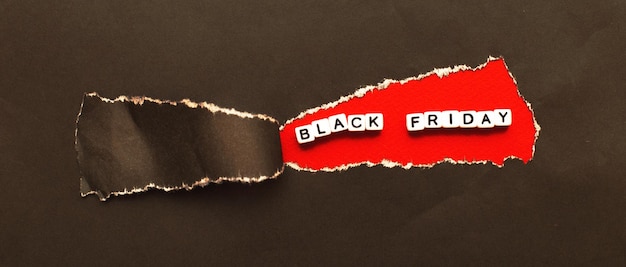 Curl of torn black paper on red background advertising and black friday sale concept banner