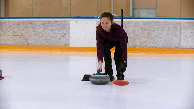 Curling training on ice rink  a young woman on the ice rink