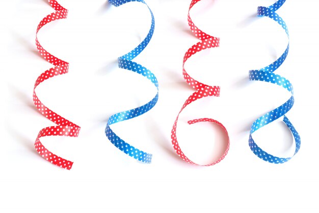 Photo curly blue and red with white polka dot ribbons isolated on white