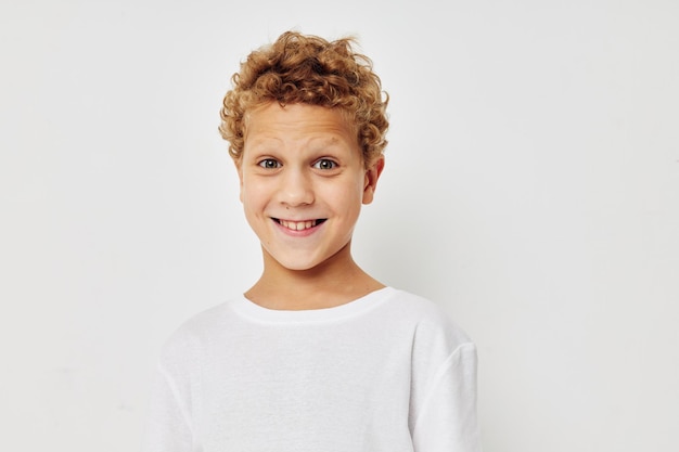 Curly boy in a white tshirt posing fun childhood unaltered