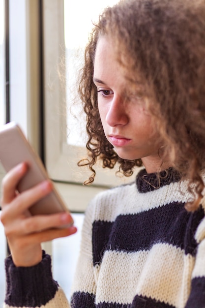 Curly hair teen girl using mobile phone