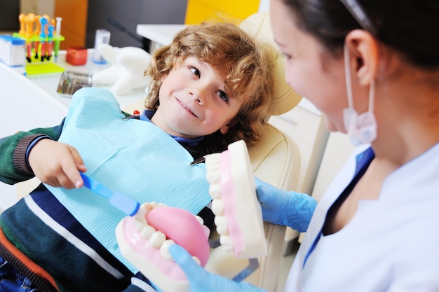 Curly-haired child indulges and grimaces in a dental chair