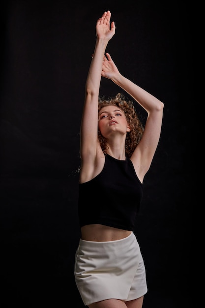 Curly thin young woman posing in the photo studio.