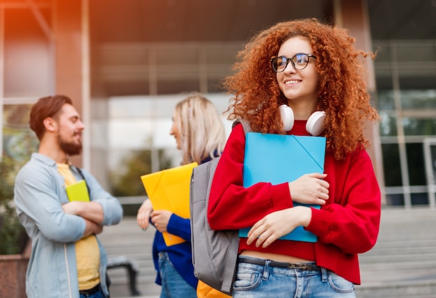 Curly young woman and student friends during college admission