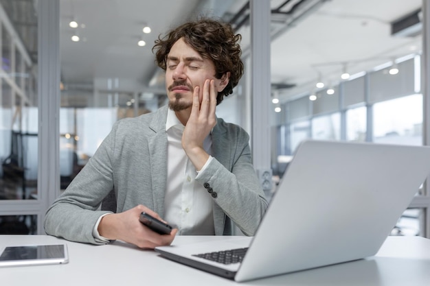 Curlyhaired experienced businessman feels discomfort in the office a corporate worker assesses pain