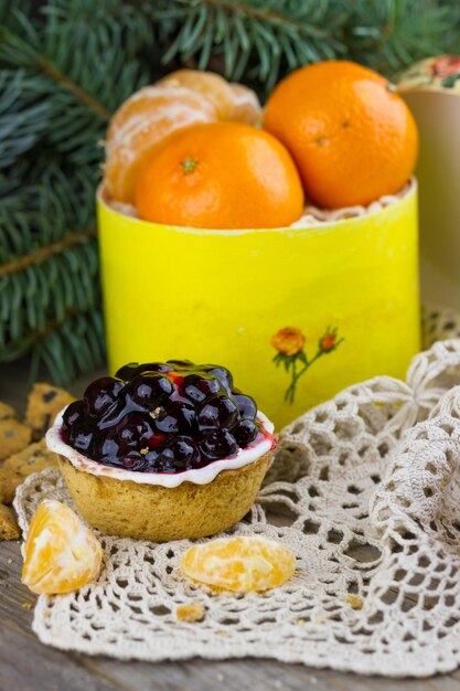 Currant cake with Christmas tangerines in a box on the table