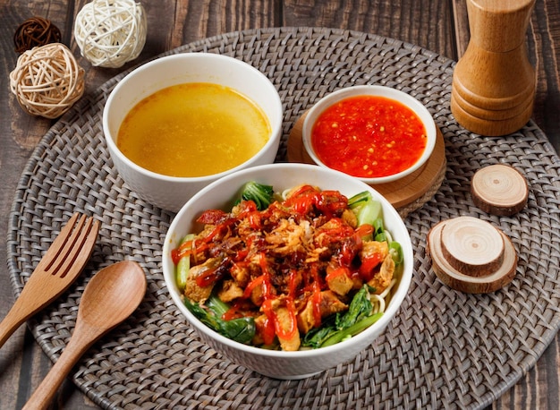 Curry Chicken Noodles with soup and red chili sauce served in dish isolated on table side view of taiwan food