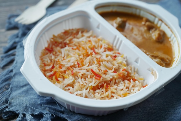 Curry chicken and rice in a take away plastic packet on table