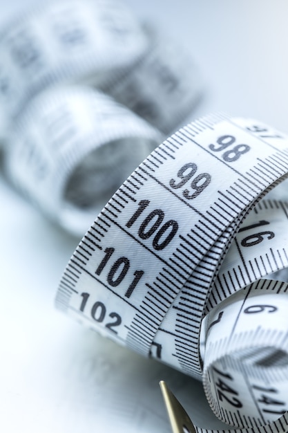 Curved measuring tape. Measuring tape of the tailor. Closeup view of white measuring tape.