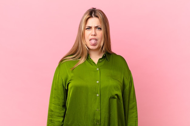 Photo curvy pretty blonde woman feeling disgusted and irritated and tongue out