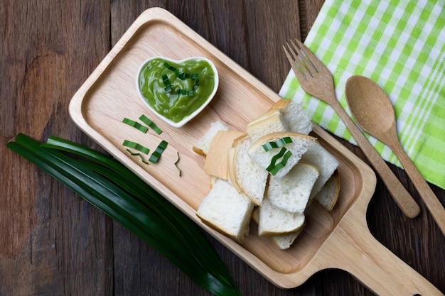 Custard bread in wooden tray and pandan paste on wooden floor 