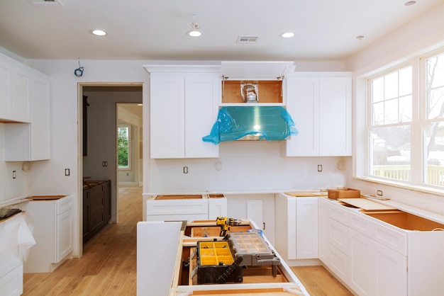 Custom kitchen cabinets in various stages of installation base for island in center installation of