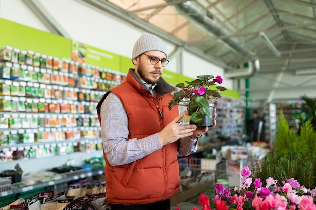 A customer chooses a potted plant as a gift in a hardware store