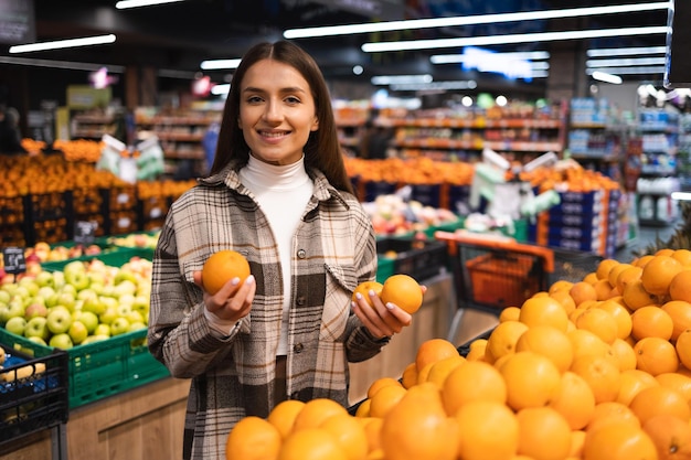 Customer choosing fresh oranges on the supermarket