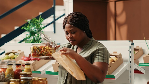 Customer pouring a type of pasta in ecological paper bag