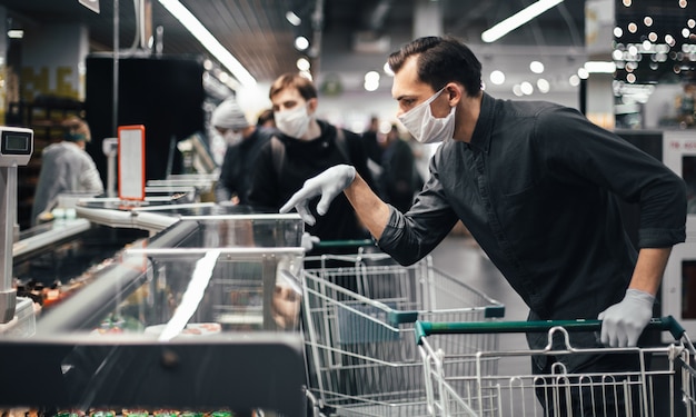 Customer in protective gloves choosing products in a supermarket. hygiene and health care