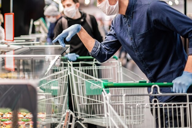 Customer in protective gloves choosing products in a supermarket. hygiene and health care