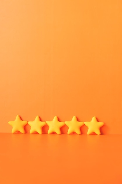 Customer review conceptRating golden stars on orange background