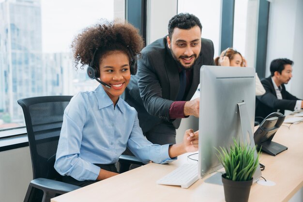 Customer service Call center operator with a friendly smile working on a computer while wearing