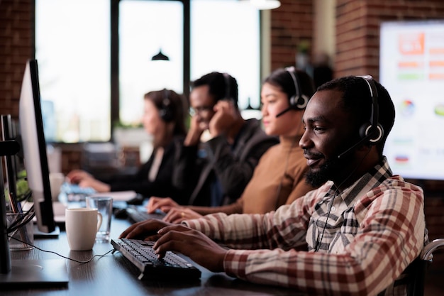 Customer service consultant with physical health condition working at call center helpdesk. Male client care operator with impairment sitting in wheelchair in disability friendly office.