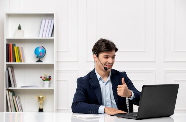 Customer service handsome guy with headset and laptop in suit showing good gesture