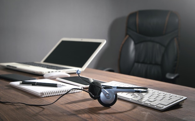 Customer service headset computer keyboard and business objects on the blue background