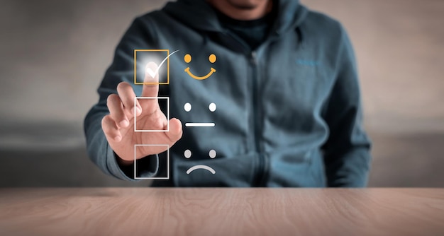 Customer service and Satisfaction concept ,Business people are touching the virtual screen on the happy Smiley face icon to give satisfaction in service. rating very impressed