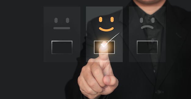 Customer service and Satisfaction concept ,Businessman are touching the virtual screen on the happy icon that shows the satisfaction of the customer.