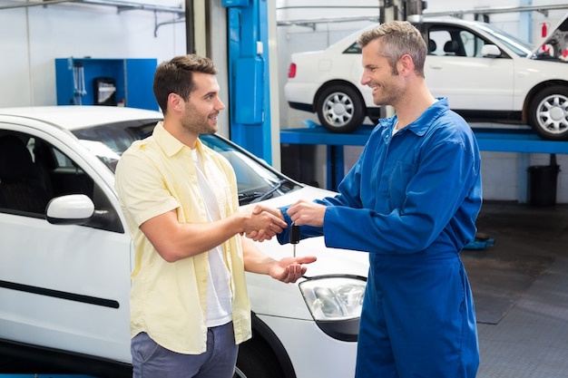 Customer shaking hands with mechanic taking keys