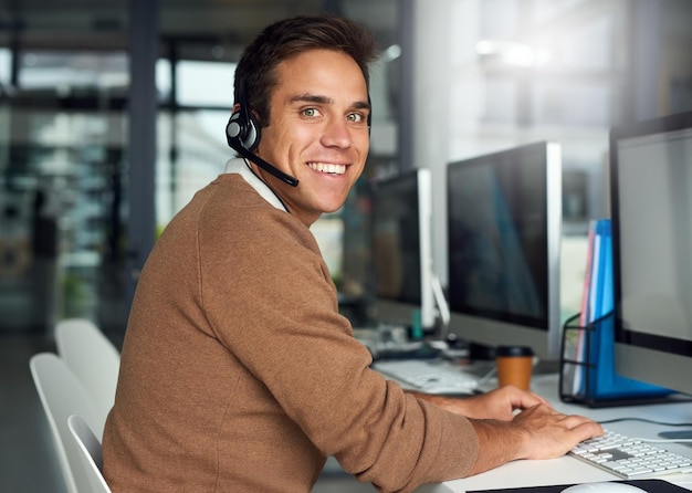 Customer support telemarketing and portrait of a man in the office doing online consultation on computer Technology contact us and male call center consultant working on crm on a pc in workplace