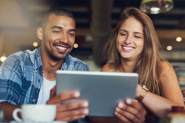 Customers get free wifi in this cafe Cropped shot of a young couple using a digital tablet while sitting in a cafe