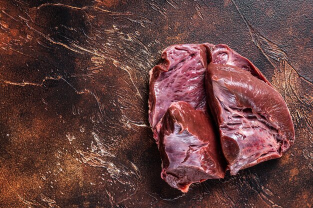 Cut Beef or veal raw heart on a butcher table.   Top View.